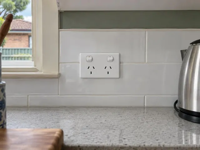 New double power point on white tiled kitchen splashback beside a bench and window in Maitland
